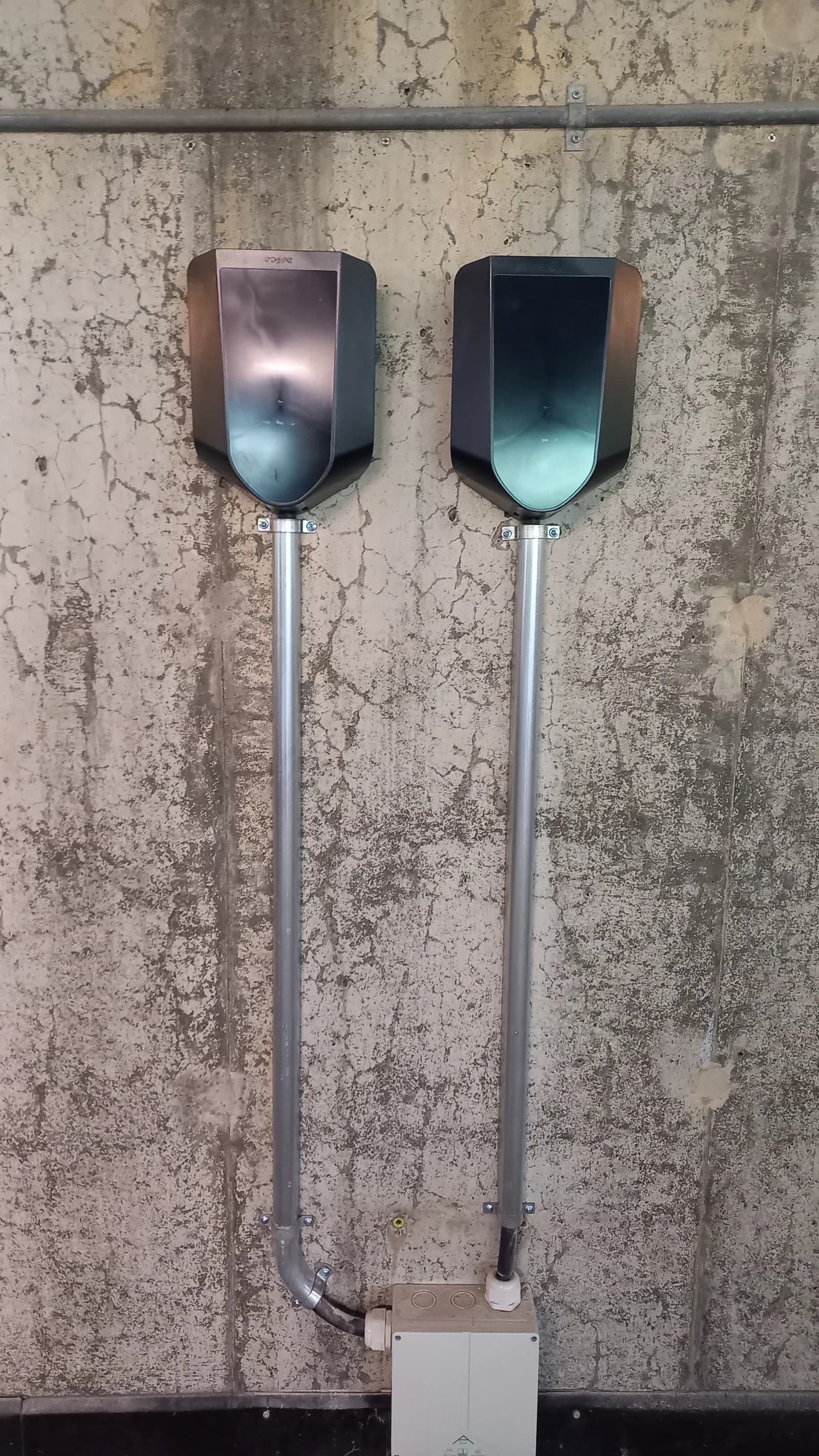 Två laddboxar på betongvägg i parkeringsgarage