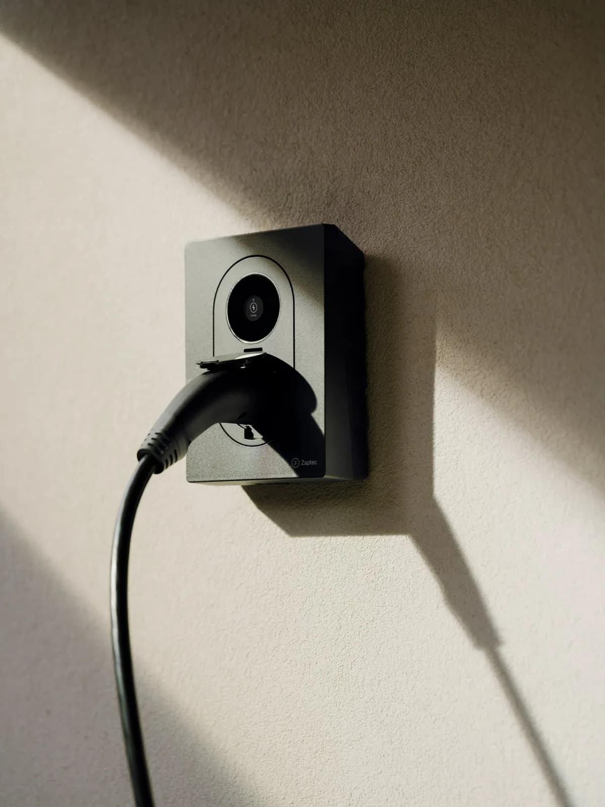 Zaptec Go 2 med laddkabel ansluten på en putsad vägg